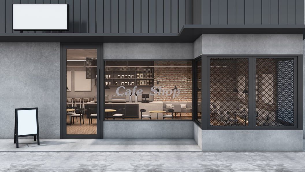Devanture d'un magasin vue de la rue, avec un stop trottoir posé sur le trottoir