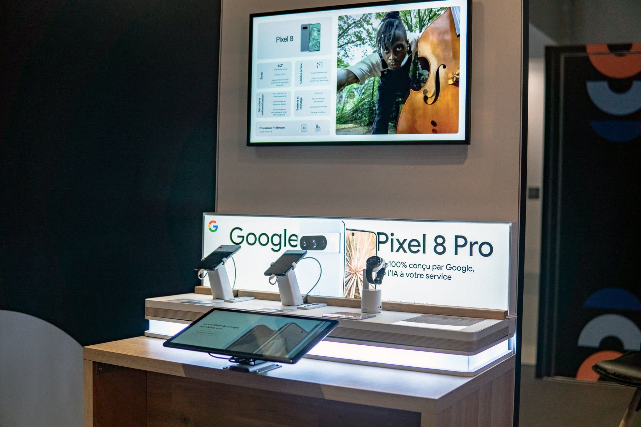Deux écrans présentant la gamme Google Pixel au-dessus du présentoir